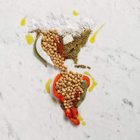 Load image into Gallery viewer, A map of North, Central, and South America covered with garbanzo beans, herbs, spices, peppers, tomato, and onion. 
