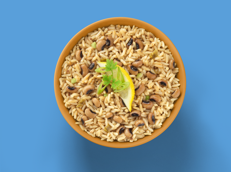 Load image into Gallery viewer, A bowl of Fillo&#39;s rice and beans with a slice of lemon and garnish.  
